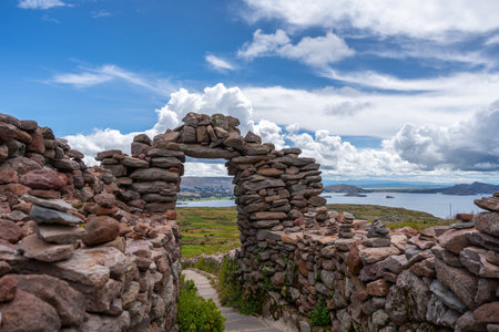 A stone arch marks the entrance to a paved path at the Pachatata archaeological site on Amantani...