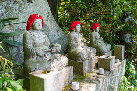 In a peaceful forest at Mitaki-Dera temple in Hiroshima, Japan. Jizo Bosatsu statues wear red...