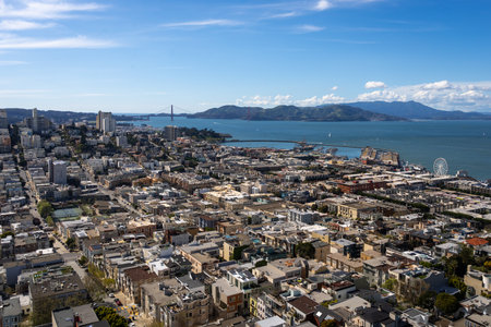 Aerial view of San Franciscoâs downtown with modern skyscrapers and the Bay Bridge under a blue sky with scattered cloudsの写真素材