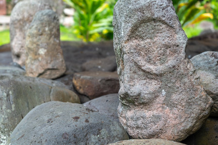 A weathered tiki head at Te Lipona in Puamau, Hiva Oa, French Polynesia. This ancient stone carving...