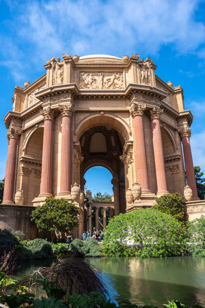 The Palace of Fine Arts in San Francisco, an architectural masterpiece with classical columns, is surrounded by lush greenery and a reflective pondの写真素材
