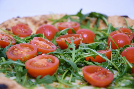 Pizza with tomatoes and rucola close-upの写真素材