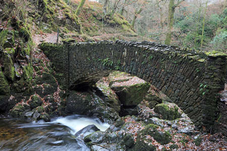 Stone bridge over waterfall, Lake District National Park, Cumbria, UKの写真素材