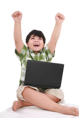 Happy little boy with laptop with moving apart his hands - indoors の写真素材