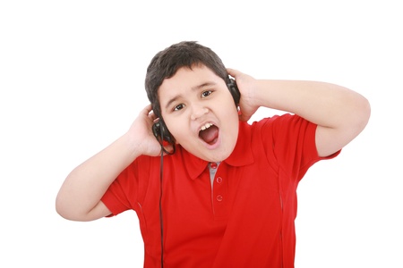 Portrait of a sweet young boy listening to music on headphones against white background の写真素材