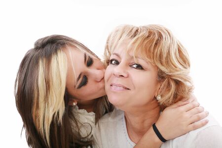 Closeup of young girl kissing her mom isolated on a white backgroundの写真素材