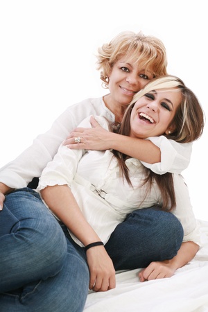 Mother and daughter sitting and laughing on the floorの写真素材
