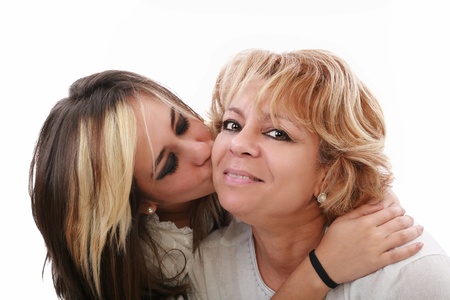 Closeup of young girl kissing her mom isolated on a white backgroundの写真素材