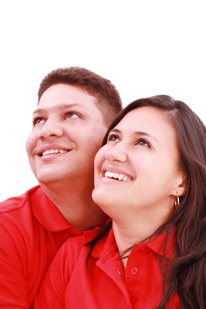 Young loving couple looking up to the sky, standing over white, smilingの写真素材