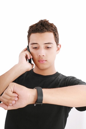 Portrait of a busy young male using mobile phone and looking at watchの写真素材