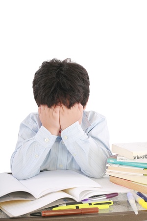 Stressed schoolboy studying in classroom の写真素材