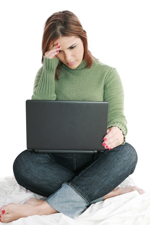 Pretty woman deep in thought while looking at laptop 
の写真素材