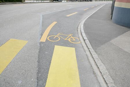 Yellow painted sign for bikes on asphalt の写真素材