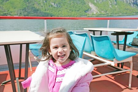 playful pretty little girl on sail boat in Luganoの写真素材
