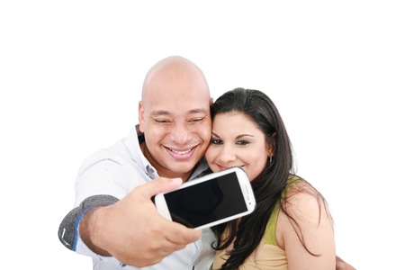 A young couple taking their picture on a mobile phone (focus on mobile phone screen) の写真素材