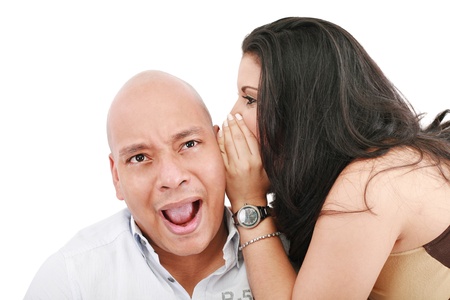 Closeup portrait of a cute young woman whispering in her husband ear の写真素材