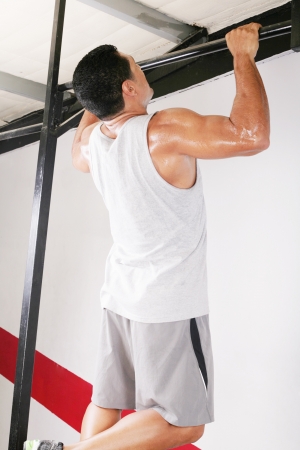 strong man performing pull ups in a bar の写真素材