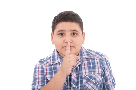 Portrait of beautiful little boy with silence gesture over white background の写真素材