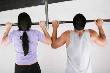 Young adult fitness woman and man preparing to do pull ups in pull up barの写真素材