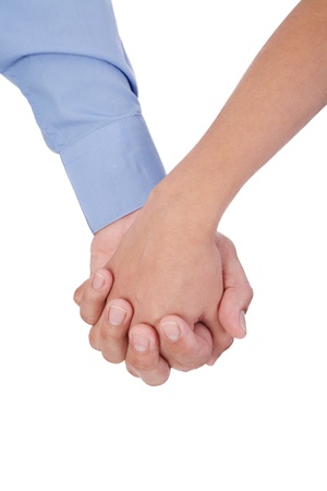 Closeup of young affectionate couple holding hands over white background. の写真素材
