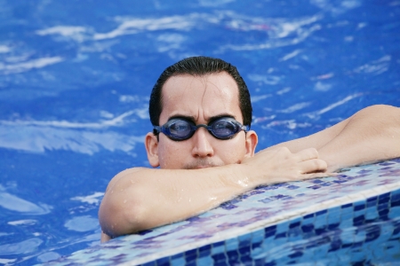 Male Swimmer resting after several laps in the indoor swimming pool の写真素材
