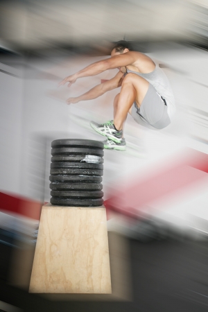 Athletic man jumping over a lot of weights 
の写真素材