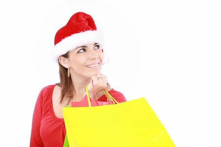 Attractive woman in Christmas cap hands packets, isolated on whiteの写真素材