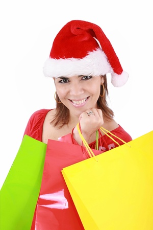 Happy woman in Santa hat holding shopping bags, over a white background. の写真素材