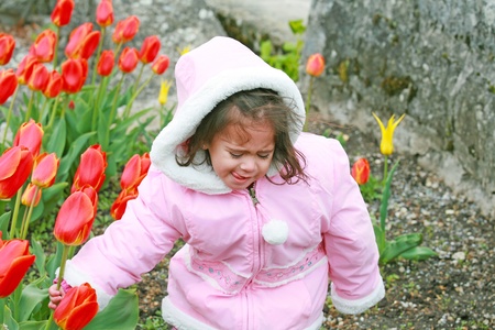 cute girl cut bouquet of red tulips on springの写真素材