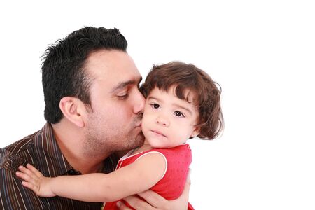 Father hugging and kissing little daughter, smiling. の写真素材