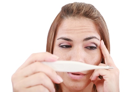 Sick woman looking at a clinical thermometer の写真素材