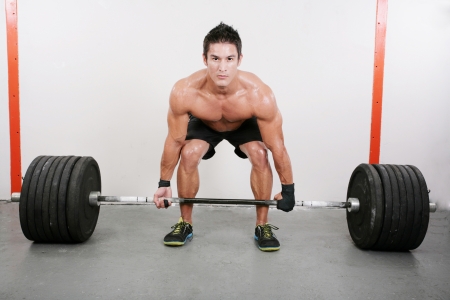 Young and muscular guy holding a barbell. Crossfit dead lift excercise. 
の写真素材
