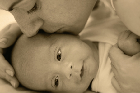 Happy young mother kissing a baby の写真素材
