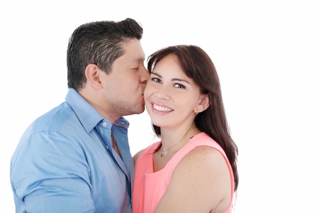 Close-up portrait of woman being affectionately kissed by her husbandの写真素材