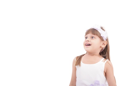 cute little girl very surprised and looking up somewhere against white background の写真素材