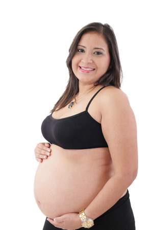 hispanic pregnant woman smiling and touching her bellyの写真素材