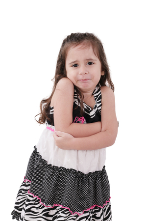 angry little girl in dress with arms crossed on white backgroundの写真素材