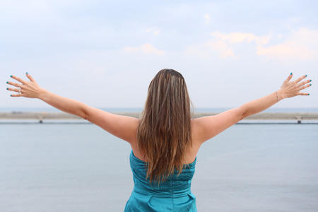 woman standing back with open armsの写真素材