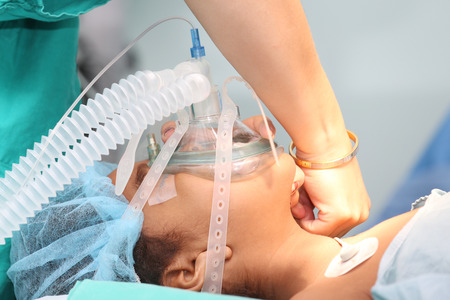 Nurse preparing the oxygen mask to an undentified patient for the surgeryの写真素材