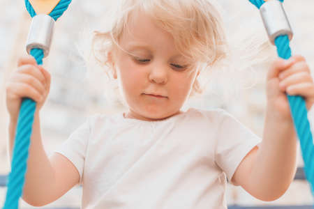 Outdoor portrait of a happy white young girl playing in playground