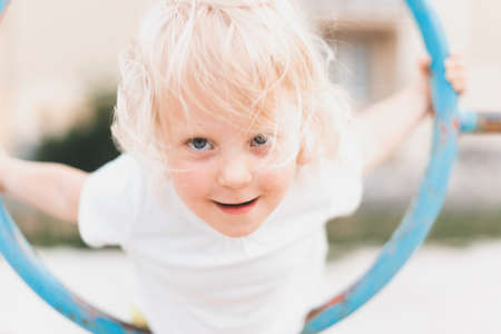 Outdoor portrait of a happy white young girl playing in playgroundの写真素材