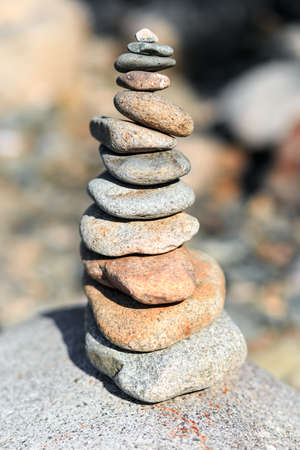 Hand building a pile of smooth stones on the beach