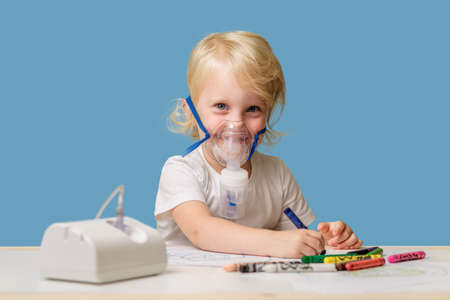 Happy child 2-3 years old in therapeutic inhalation mask at homeの写真素材