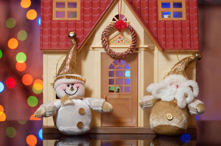 Santa Claus and Snowman against the beautiful house
