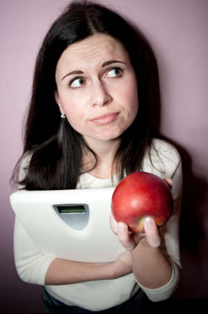 young woman reflects to grow thin her or notの写真素材