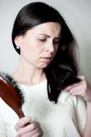 shocked girl looks at the cut tags of the hairsの写真素材