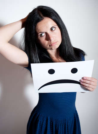 Woman holding a blank paper with sad faceの写真素材