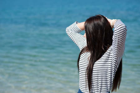 young woman enjoying the beach on a sunny summer dayの写真素材