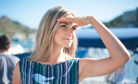 young blonde in a turquoise dress Ð³ÑÐ´ÑÐµÑ on the embankment. sun. summer. relaxの写真素材
