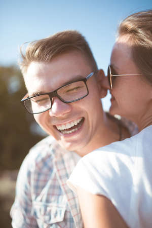 Young man and woman having fun outdoor in summer. man in a plaid shirt, the woman in a white dress. love. family. smileの写真素材